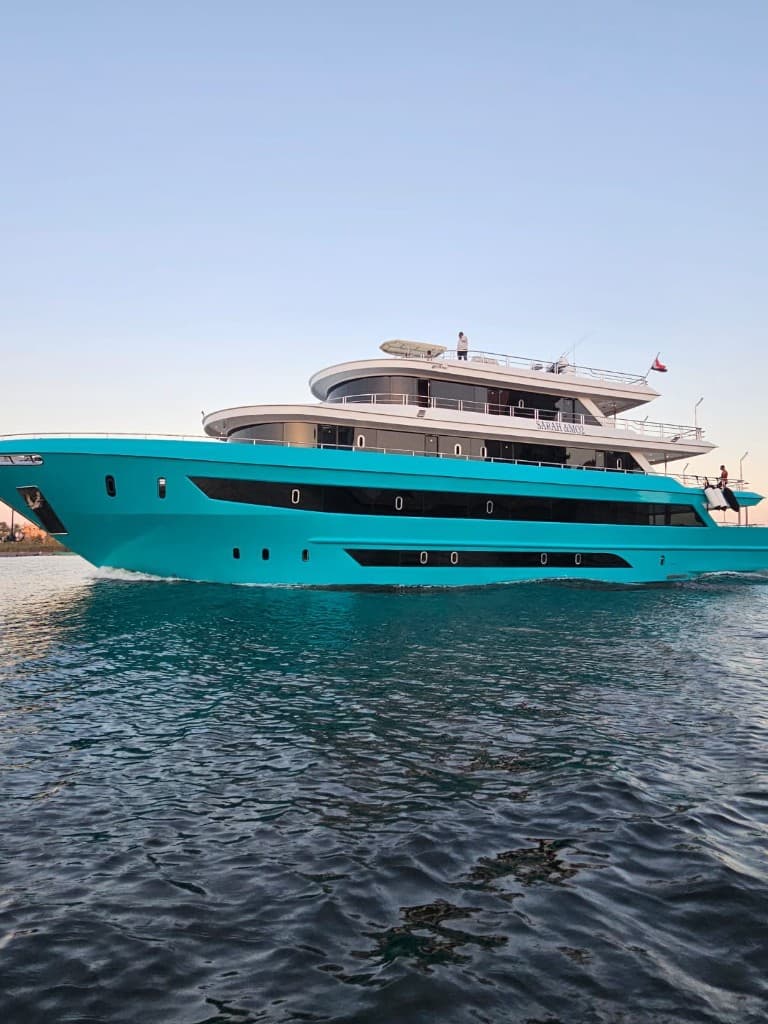 SARAH & MO 2 approaching, five decks above a turquoise hull.